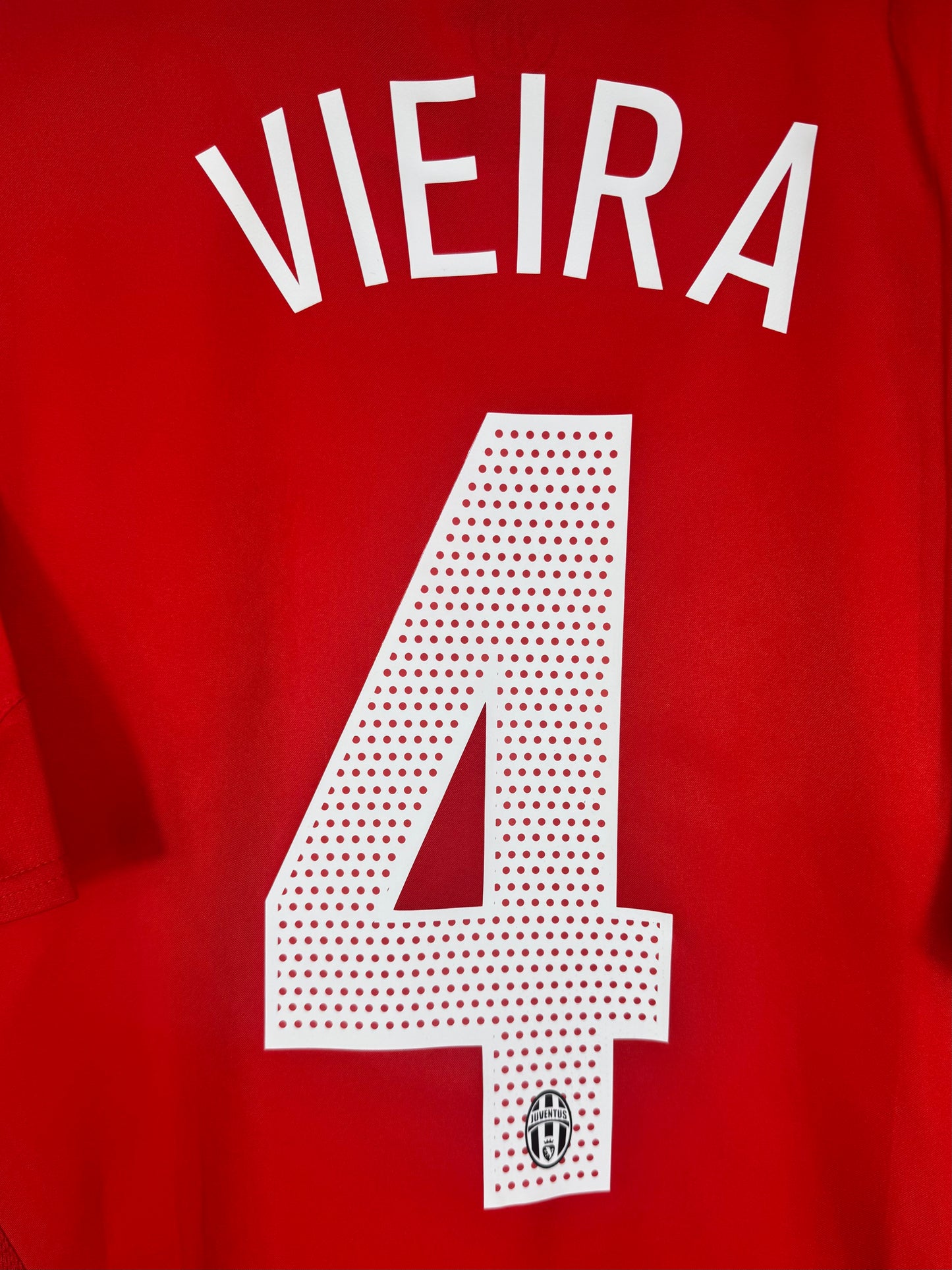 Zoom sur le nom VIEIRA et le numéro 4 blanc avec motif rayé officiel.