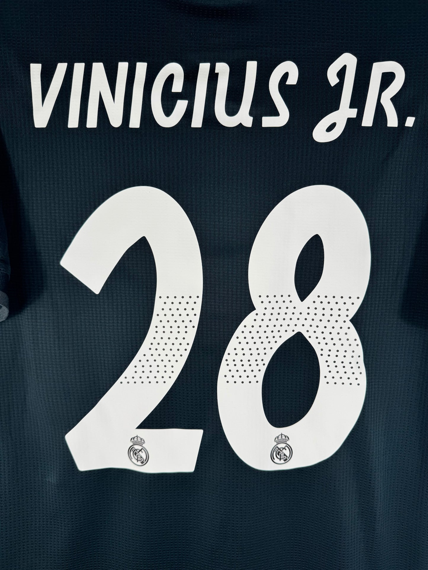 Zoom sur le nom VINICIUS JR et le numéro 28 blanc, typographie officielle utilisée en Ligue des Champions.