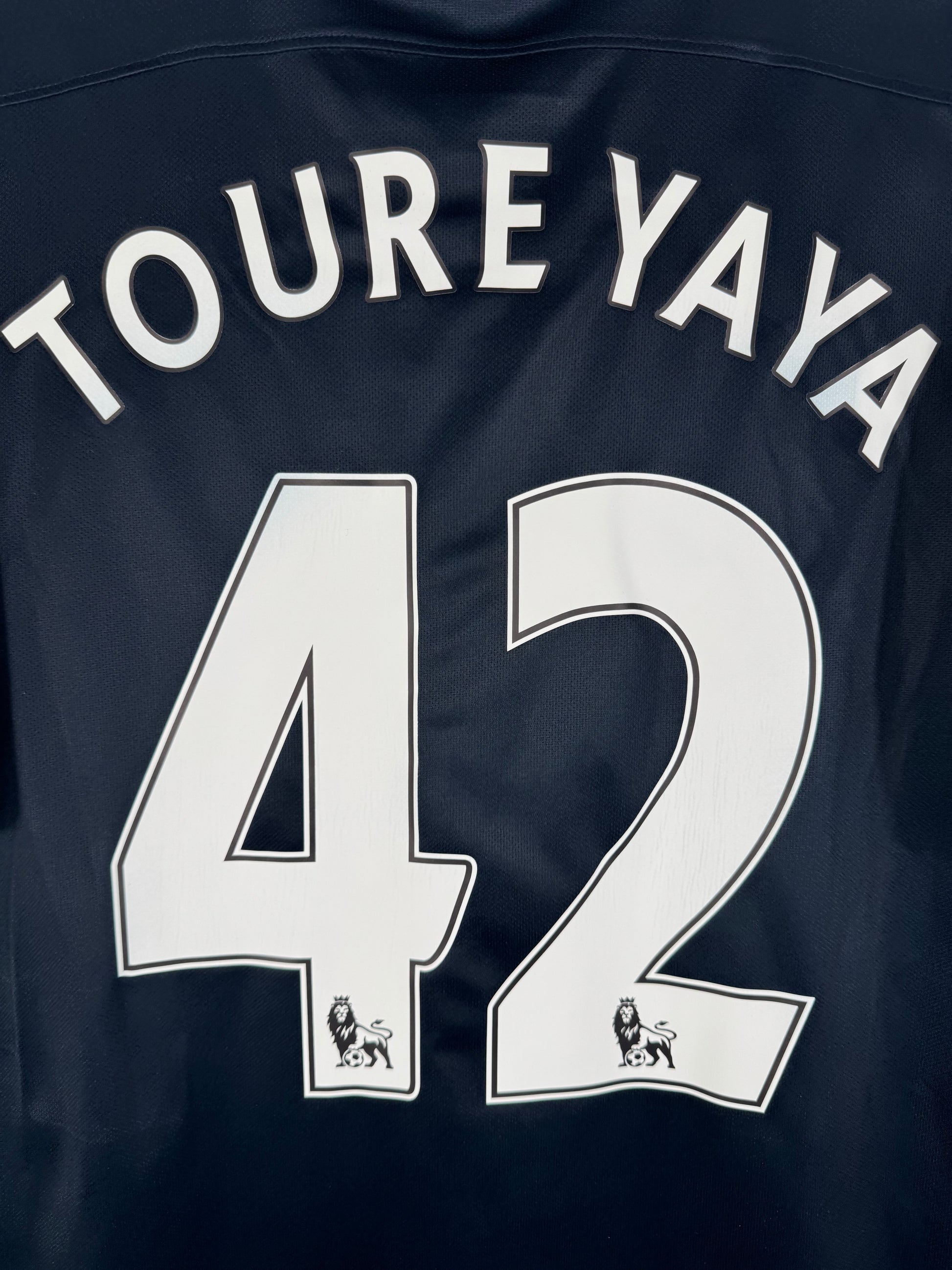 Zoom sur le nom YAYA TOURÉ et le numéro 42 blanc, police officielle Premier League 2016.