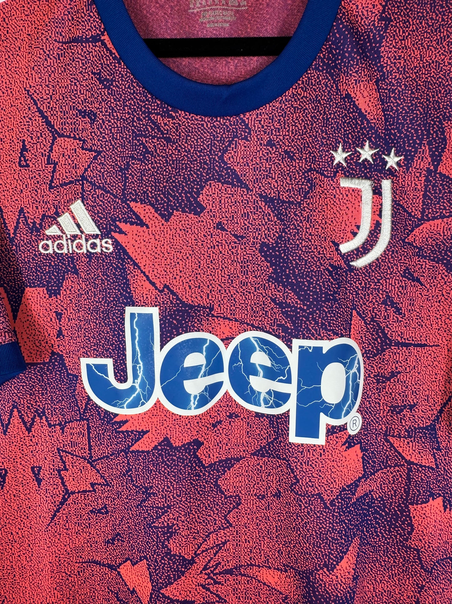 Gros plan sur le logo J, le logo Adidas blanc et le sponsor Jeep avec effet éclairs.