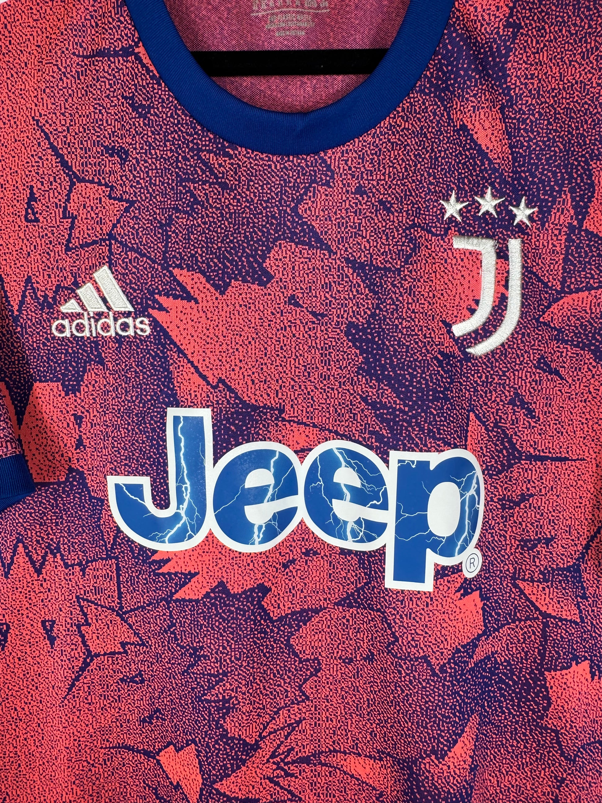 Gros plan sur le logo J, le logo Adidas blanc et le sponsor Jeep avec effet éclairs.