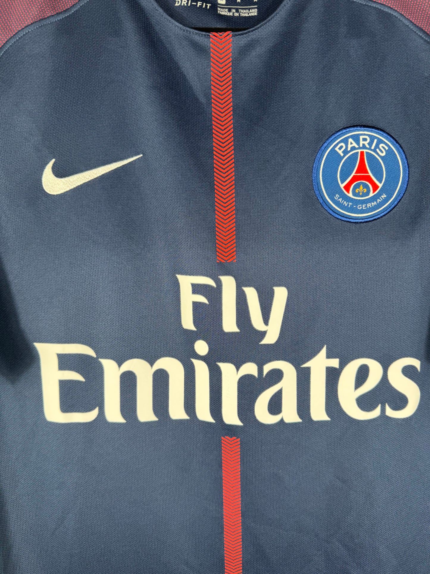 Gros plan sur le logo Nike jaune, l'écusson du PSG et le sponsor Fly Emirates sur le maillot 2018.