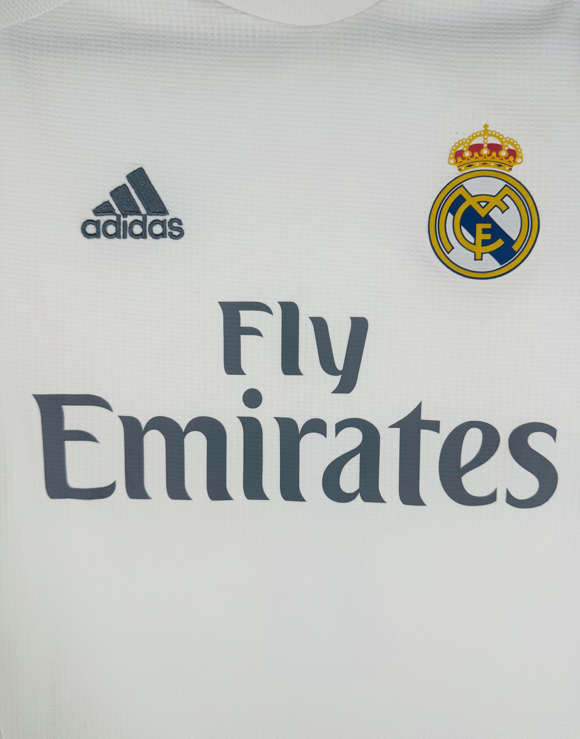 Gros plan sur l'écusson du Real Madrid et logo Adidas sur le maillot domicile 2015-2016.