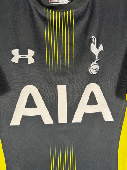 Gros plan sur l'écusson de Tottenham Hotspur et le logo Under Armour sur le torse.