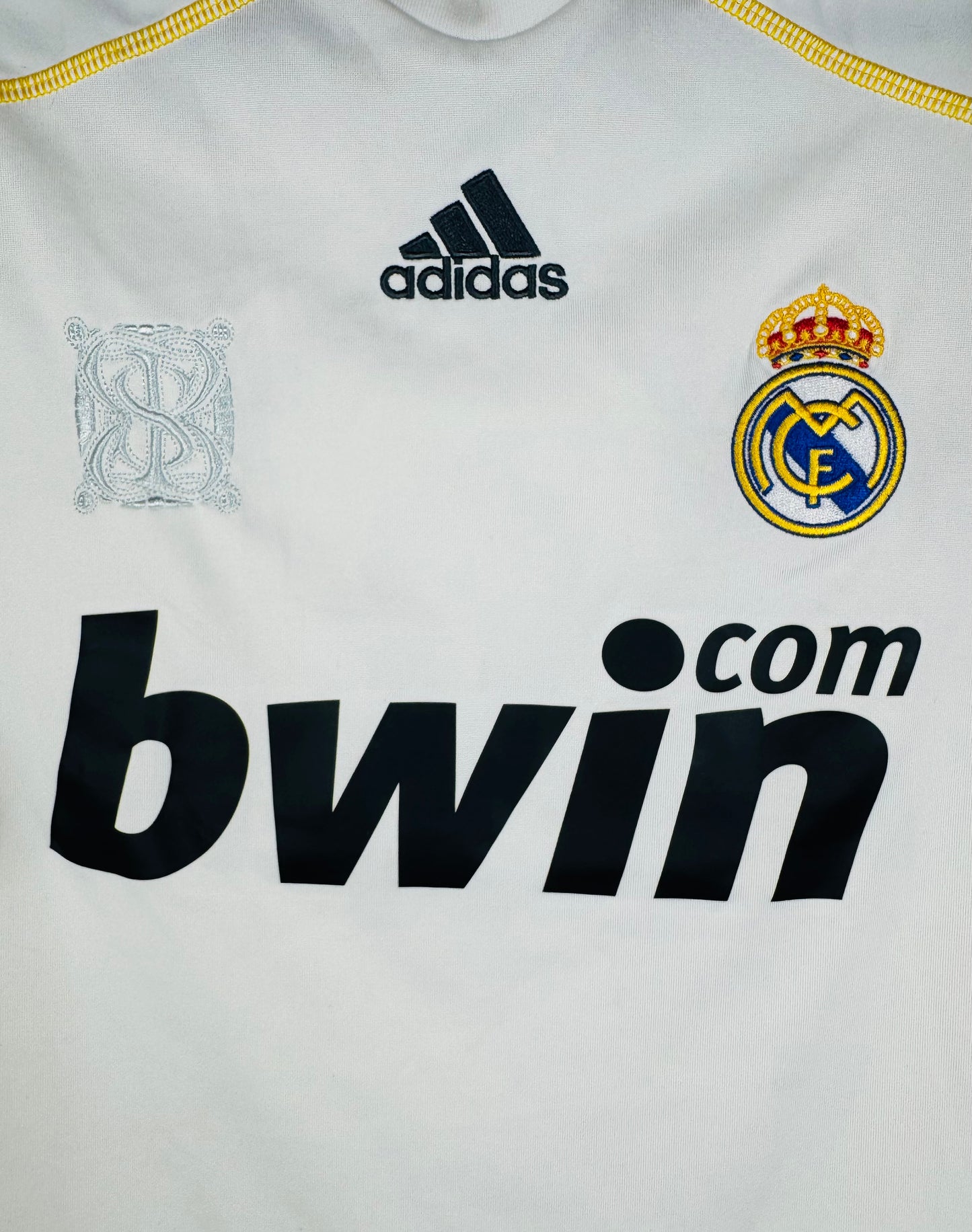 Gros plan sur le logo Adidas, le sponsor Bwin et le filigrane du stade Santiago Bernabéu.