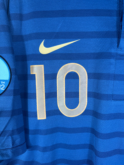 Gros plan sur le logo Nike doré et le numéro 10 sur le torse du maillot français à rayures.