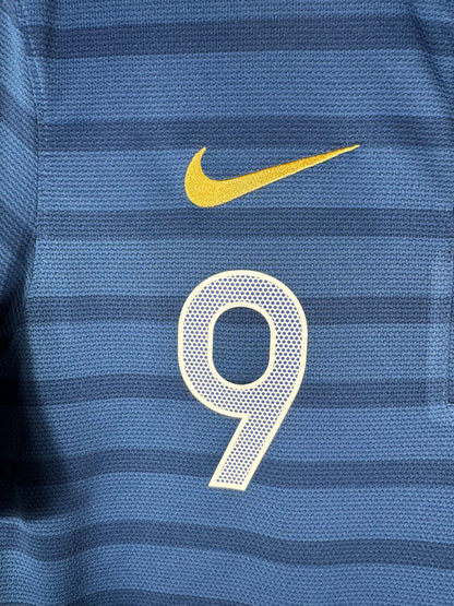 Gros plan sur le logo Nike doré et le numéro 9 sur le torse du maillot français.