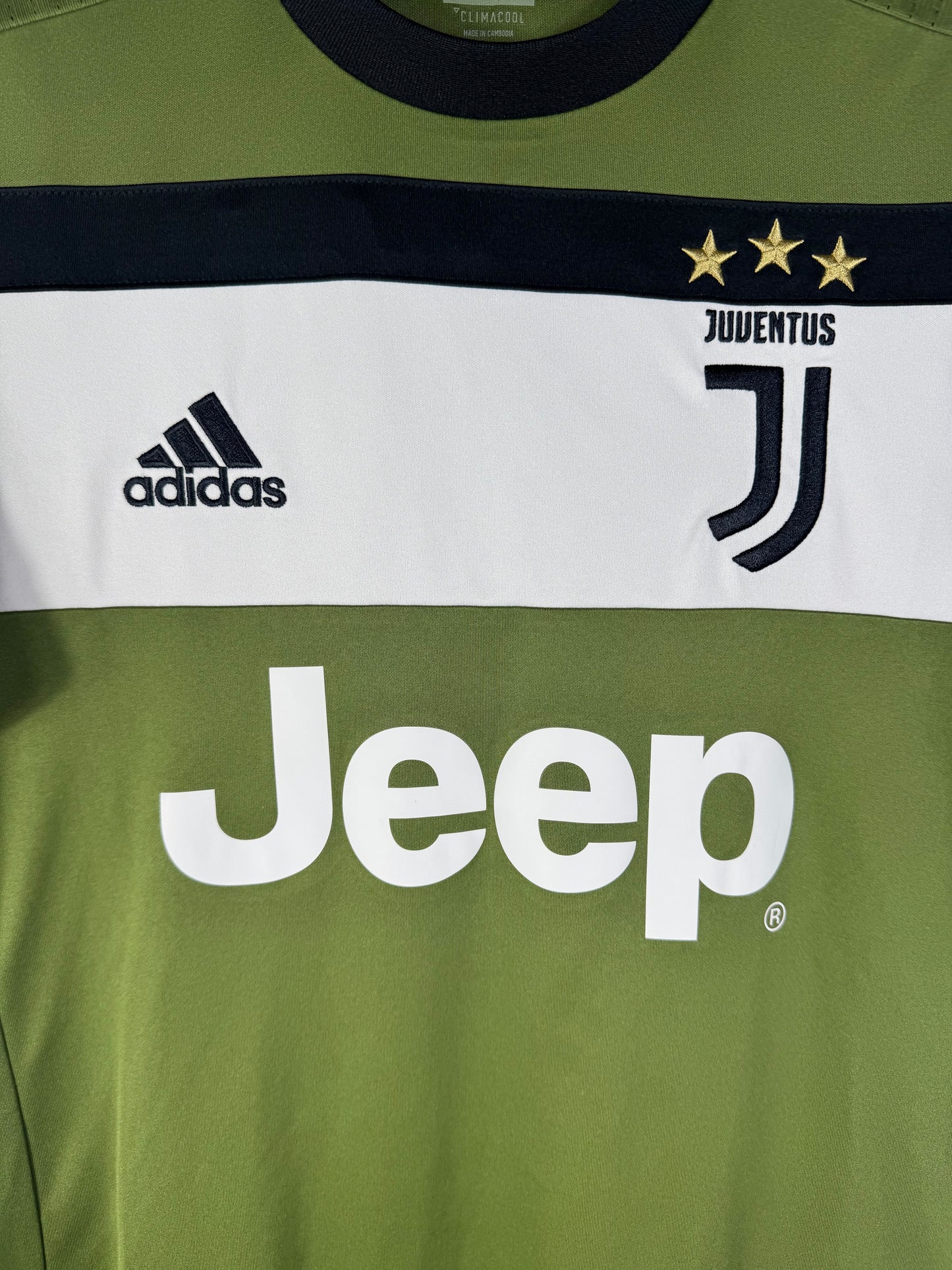 Gros plan sur le nouveau logo J de la Juventus, les 3 étoiles d'or et le sponsor Jeep sur le maillot vert.