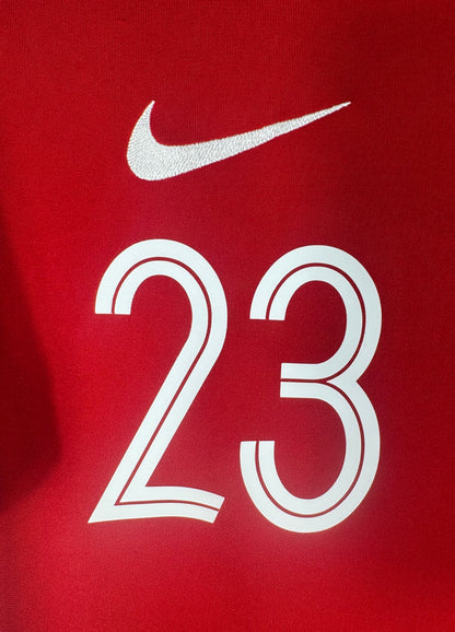 Gros plan sur le numéro 23 blanc et le logo Nike blanc sur fond rouge.
