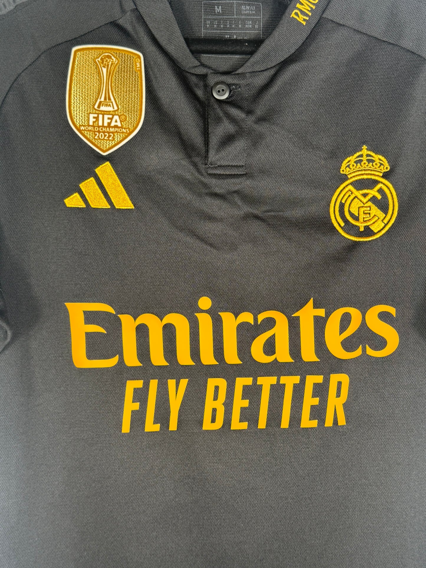 Gros plan sur le badge FIFA World Champions 2022 et le logo Adidas jaune.