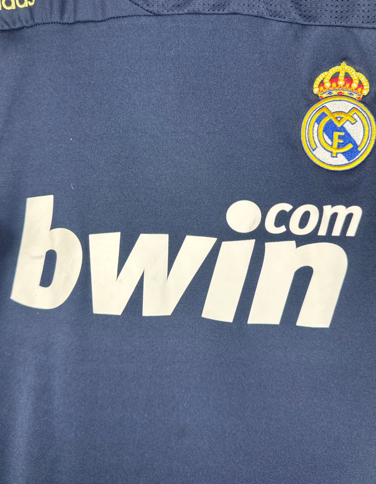 Gros plan sur le sponsor bwin.com et l'écusson du Real sur fond bleu.