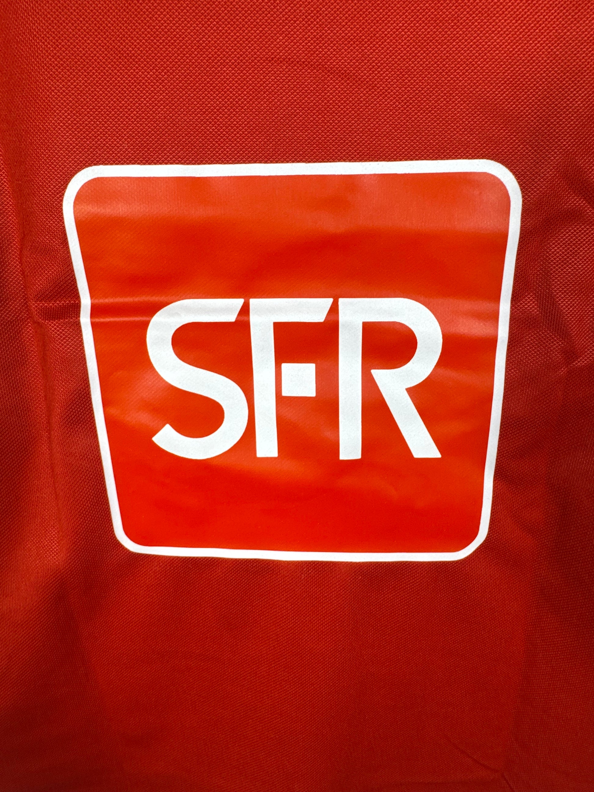 Zoom sur le large sponsor carré SFR plaqué au dos du maillot.