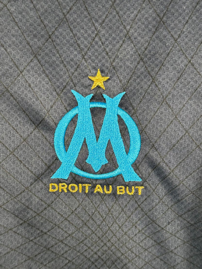 Détail écusson Olympique de Marseille et motif géographique maillot extérieur.