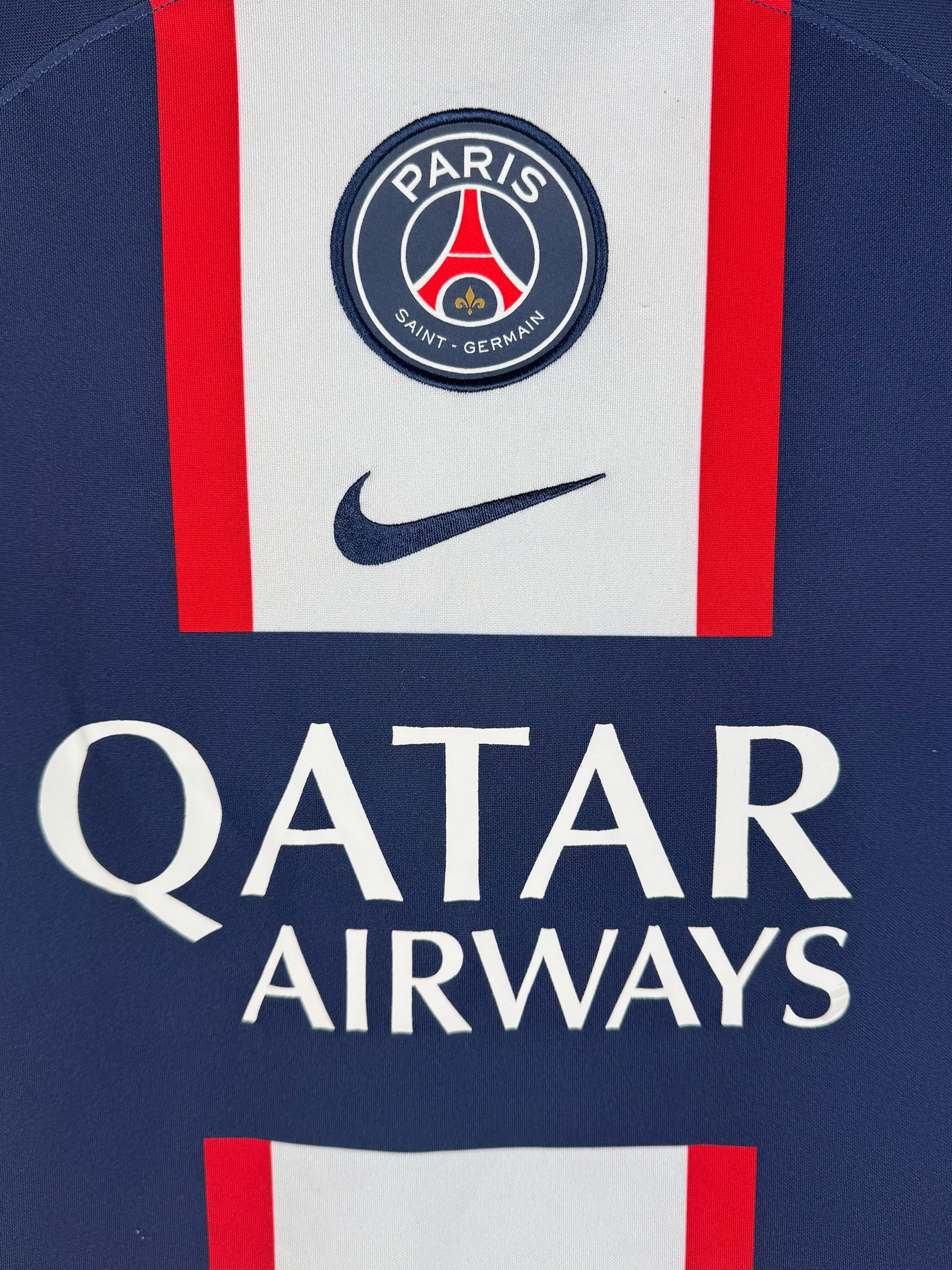 Détail écusson Paris Saint-Germain et sponsor Qatar Airways sur maillot domicile.