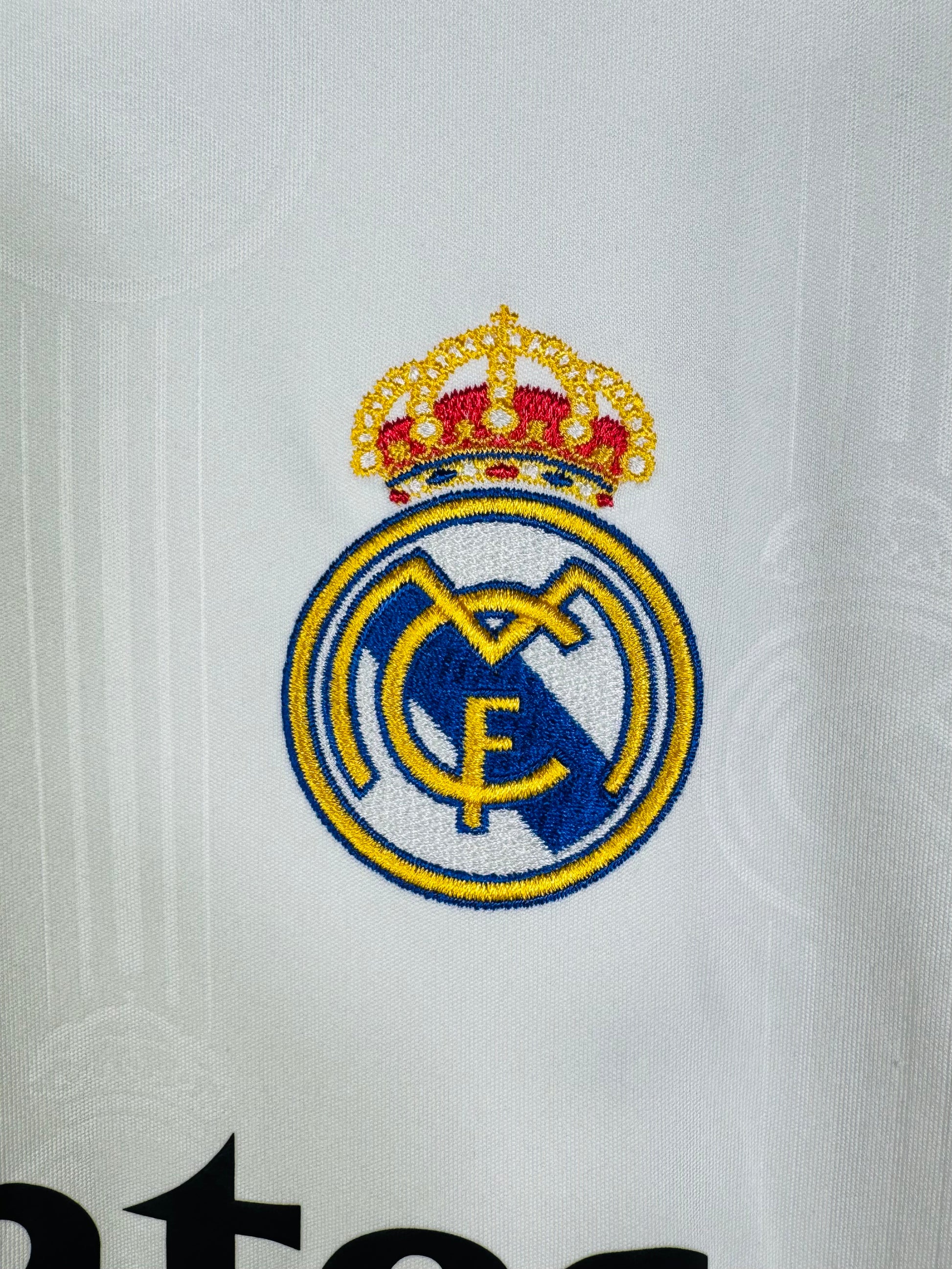 Détail broderie écusson Real Madrid sur maillot domicile 2022.