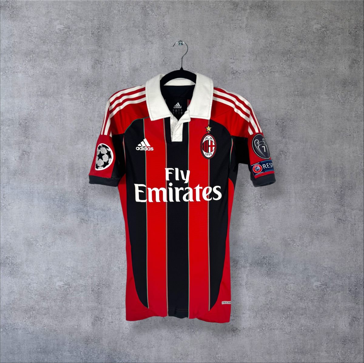 Face du maillot AC Milan 2012-2013 domicile rayé rouge et noir, col polo blanc et sponsor Fly Emirates