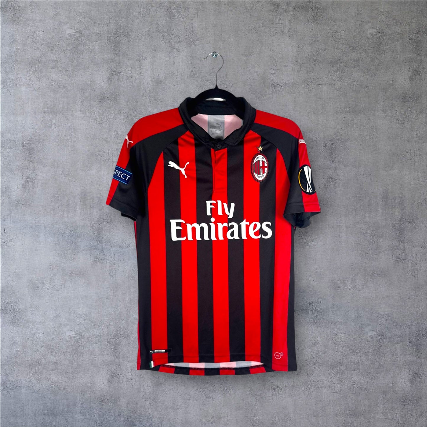 Vue de face du maillot AC Milan 2018/19 à rayures rouges et noires classiques.