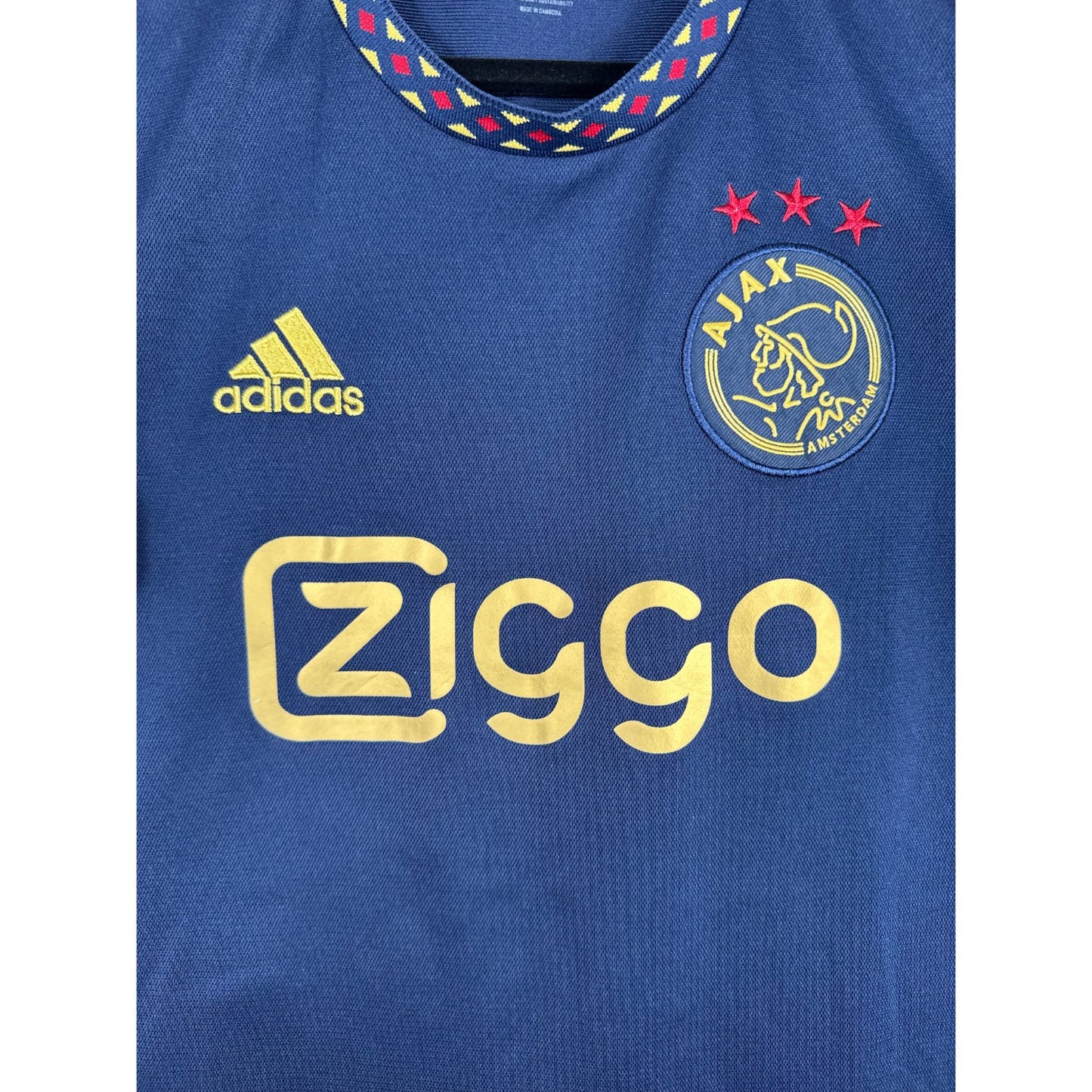 Détail de l'écusson de l'Ajax et du logo Adidas dorés