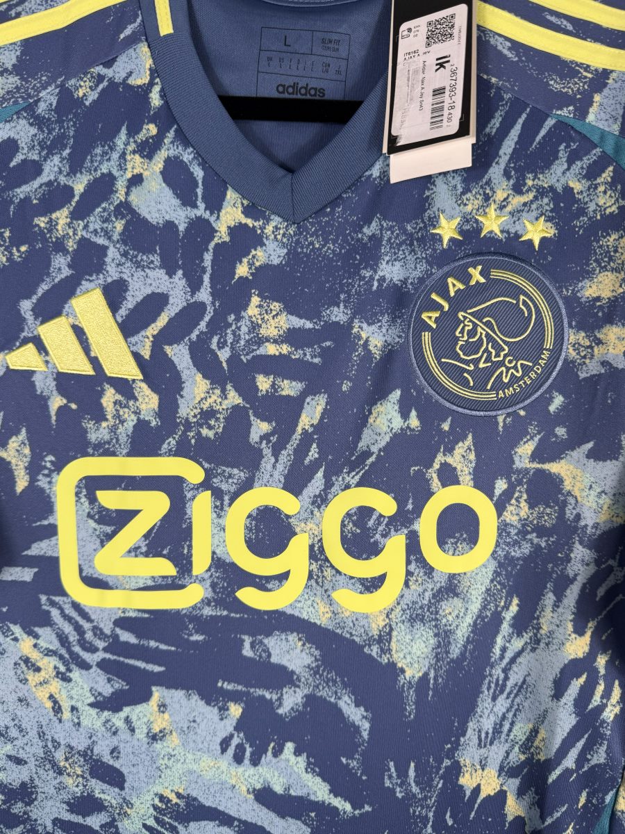 Détail de l'écusson Ajax à trois étoiles et du sponsor Ziggo sur le maillot extérieur 2024-2025