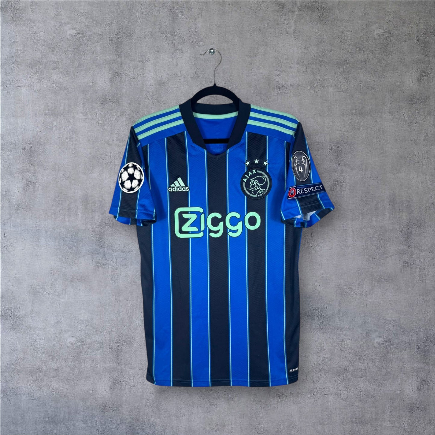 Vue de face du maillot Ajax Amsterdam Extérieur 2022 rayé bleu et noir sponsor Ziggo.