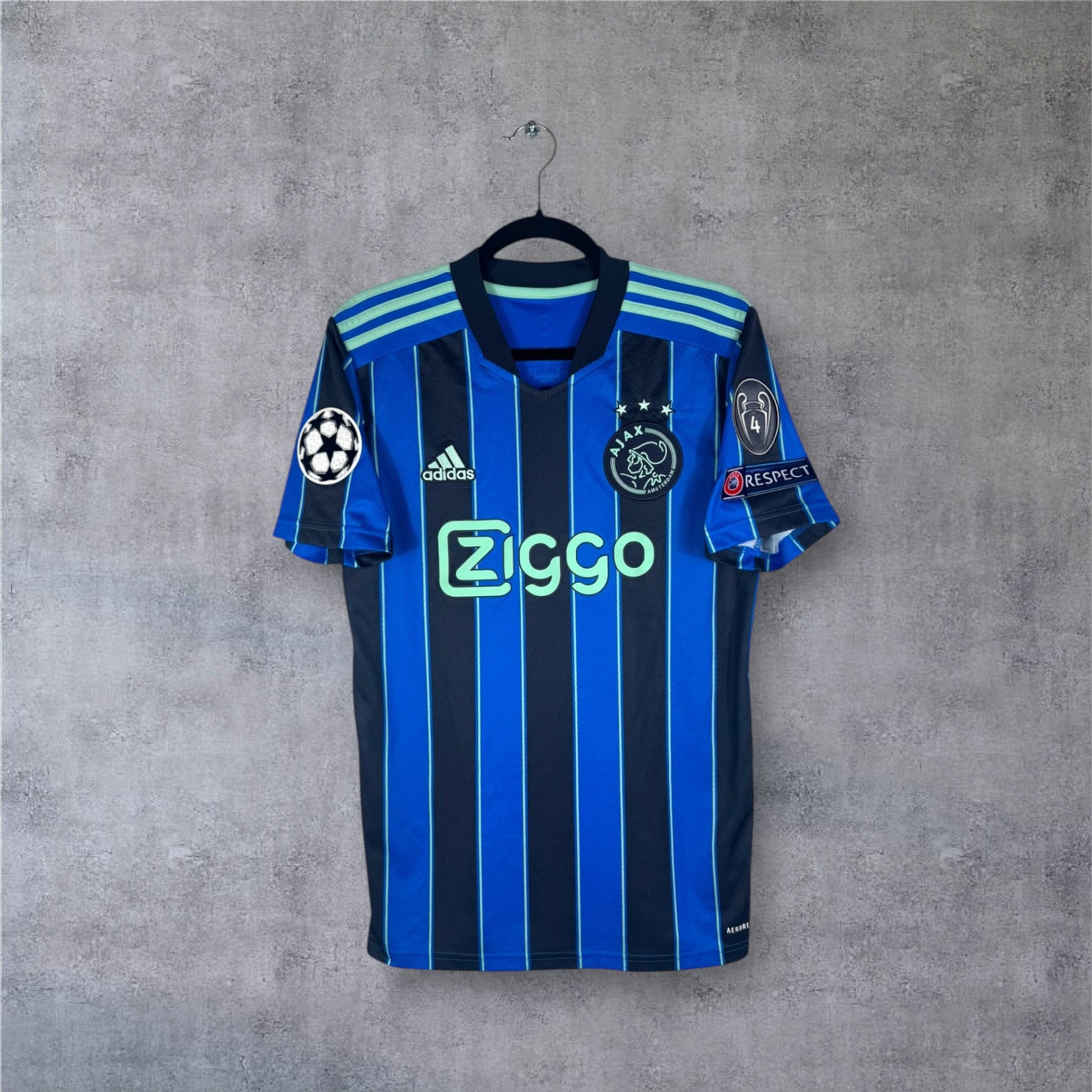 Vue de face du maillot Ajax Amsterdam Extérieur 2022 rayé bleu et noir sponsor Ziggo.