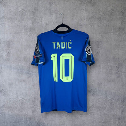 Dos du maillot Ajax bleu et noir avec flocage vert TADIĆ 10 et patchs LDC.