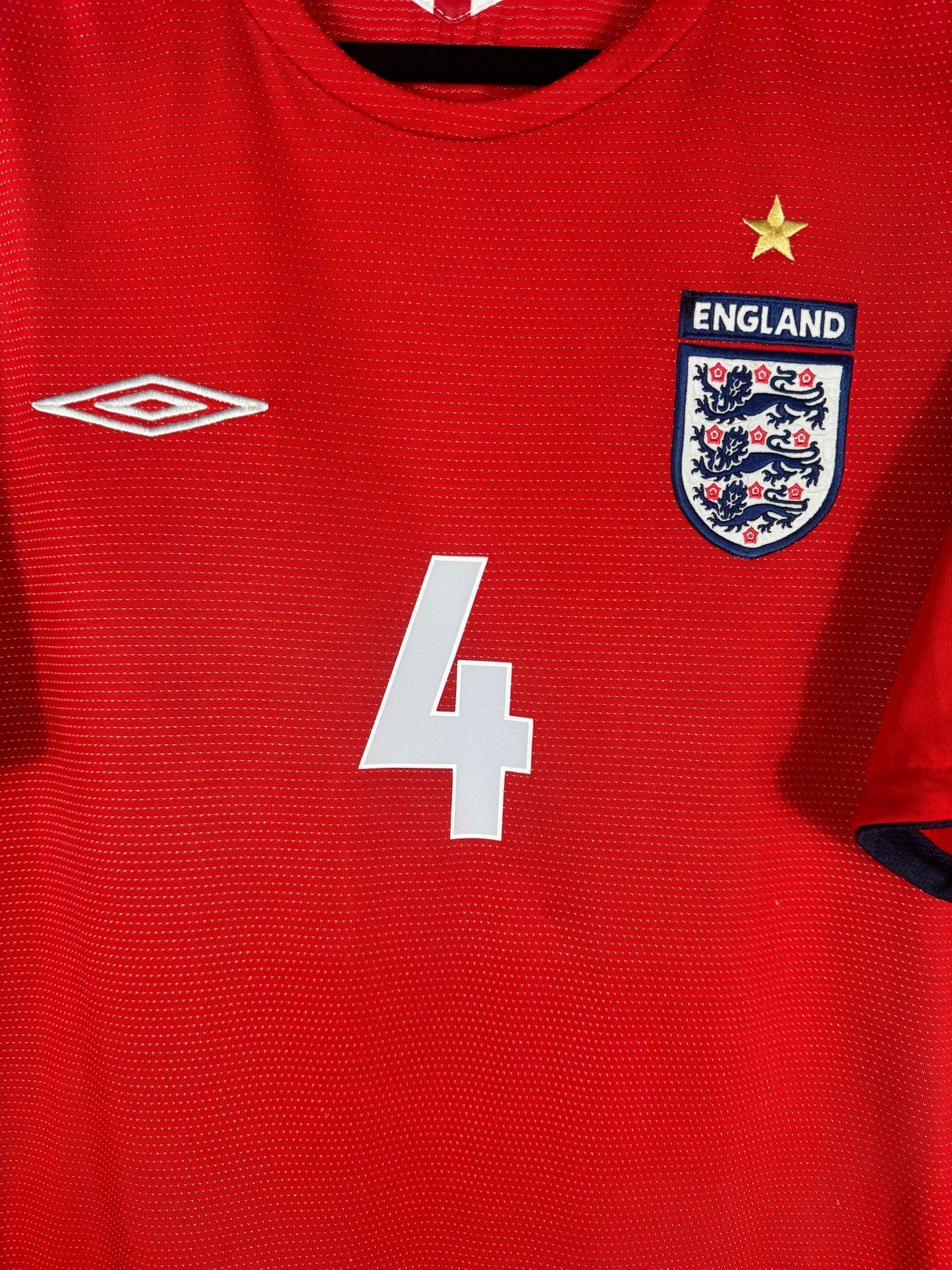 Détail écusson Three Lions et logo Umbro brodés sur maillot Angleterre Euro 2004