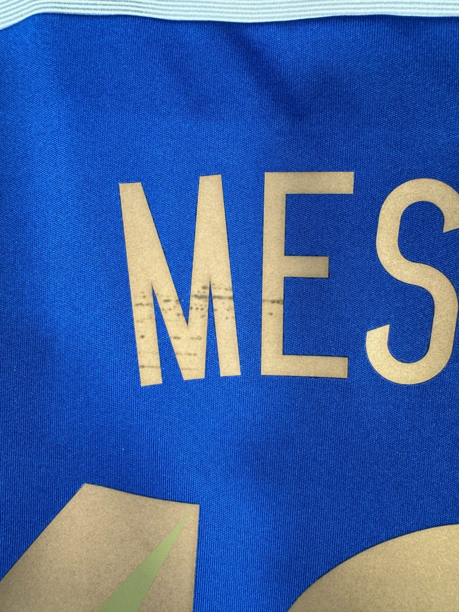 Légères craquelures sur le M du flocage Messi, maillot Argentine extérieur 2014