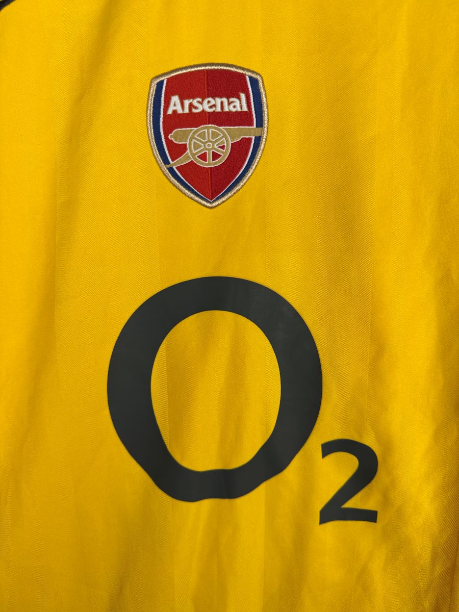 Détail de l'écusson brodé Arsenal et du sponsor O2 sur le maillot extérieur jaune 2005-2006