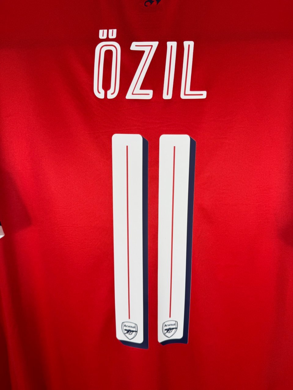 Détail de la typographie du flocage sur le numéro 11 de Mesut Özil