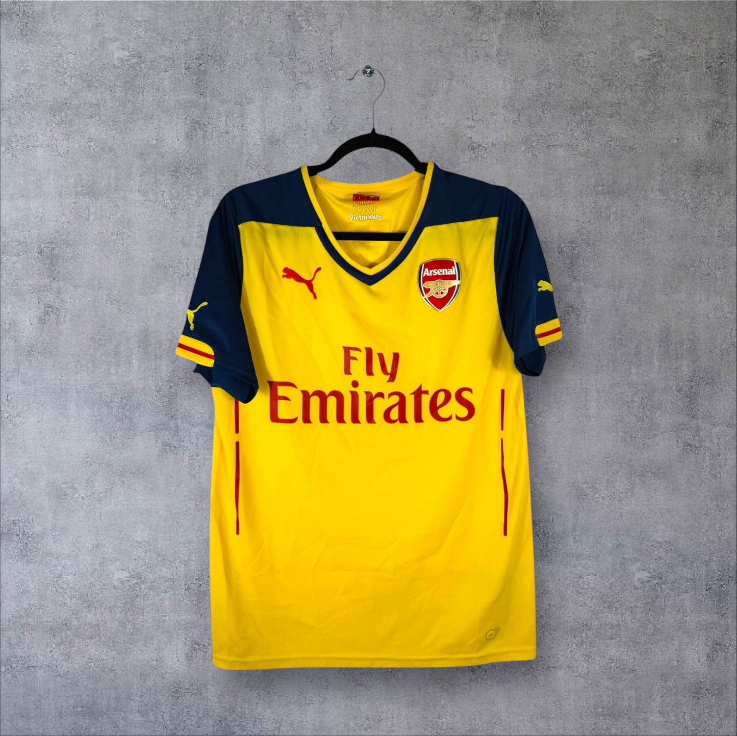 Vue de face du maillot Arsenal Extérieur 2014/15 jaune avec manches bleu marine et sponsor Fly Emirates.
