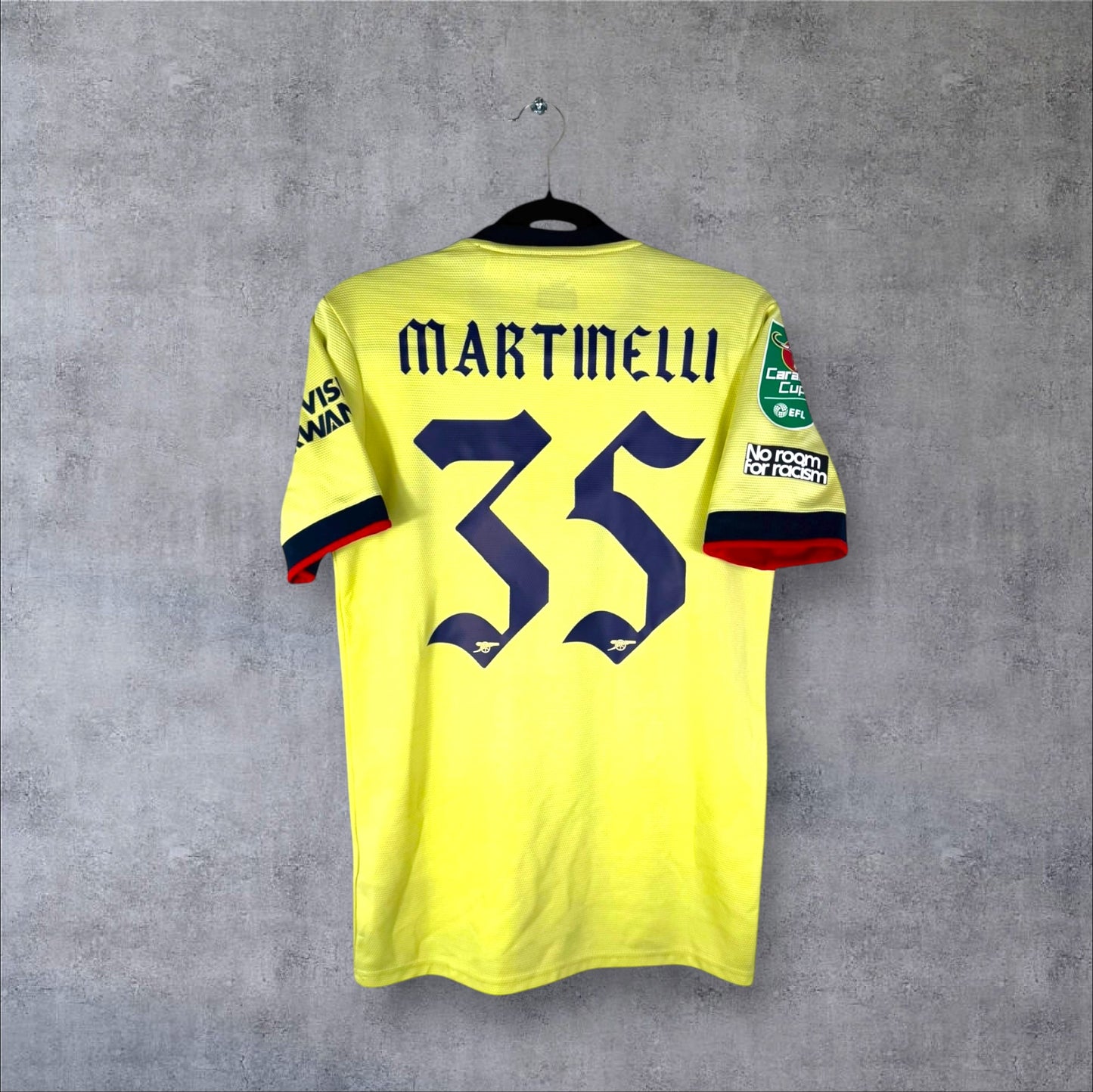 Dos du maillot Arsenal Extérieur 2022 jaune perle avec flocage bleu marine MARTINELLI 35 en police gothique et patch Carabao Cup.