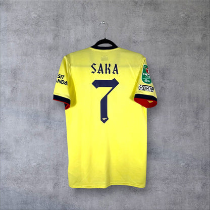 Dos du maillot Arsenal Extérieur 2022 jaune perle avec flocage bleu marine SAKA 7 en police gothique et patch Carabao Cup.