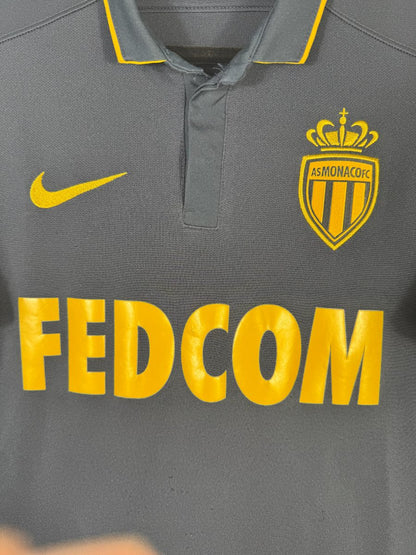 Écusson brodé de l AS Monaco surmonté de la couronne, au-dessus du sponsor FEDCOM