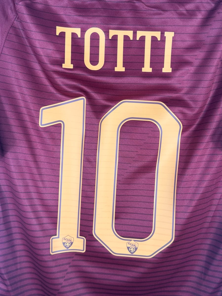 Gros plan du flocage TOTTI N°10 avec l'écusson de la Louve intégré aux chiffres