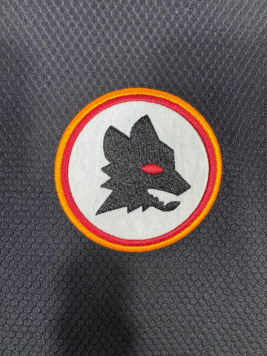 Détail de l'écusson lupetto rétro brodé de l'AS Roma sur le maillot third 2023-2024