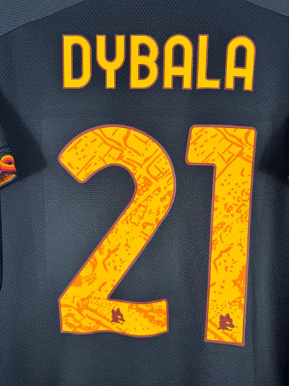 Gros plan du flocage Dybala N°21 jaune à motif romain avec têtes de loup intégrées, maillot third 2023-2024