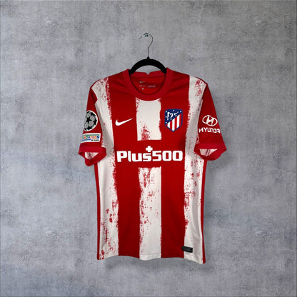 Maillot Atlético Madrid domicile 2021-2022 Nike de face, rayures rouges et blanches, sponsor Plus500