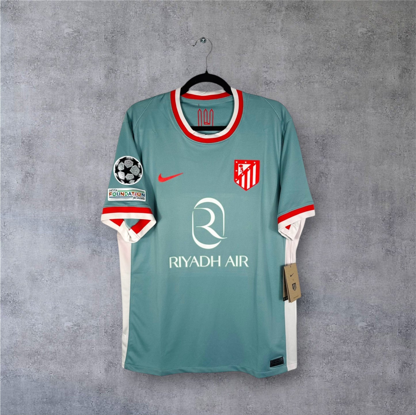 Vue de face du maillot Atletico Madrid Extérieur 2024/25 beige, sponsor Riyadh Air et logo historique.