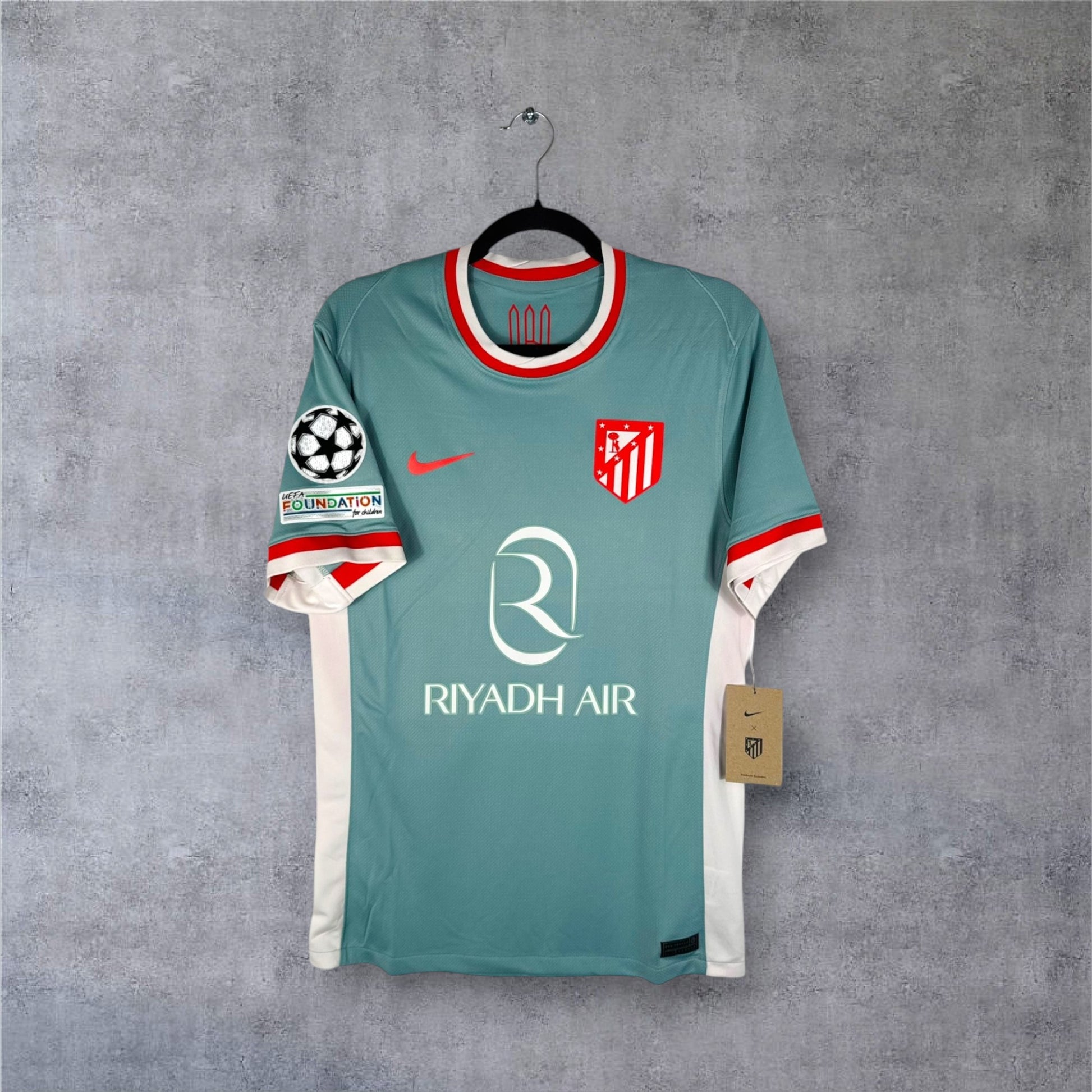 Vue de face du maillot Atletico Madrid Extérieur 2024/25 beige avec sponsor Riyadh Air.