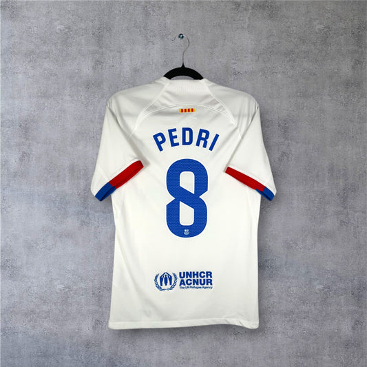 Flocage officiel bleu PEDRI numéro 8 et sponsor UNHCR au dos du maillot blanc Barça.