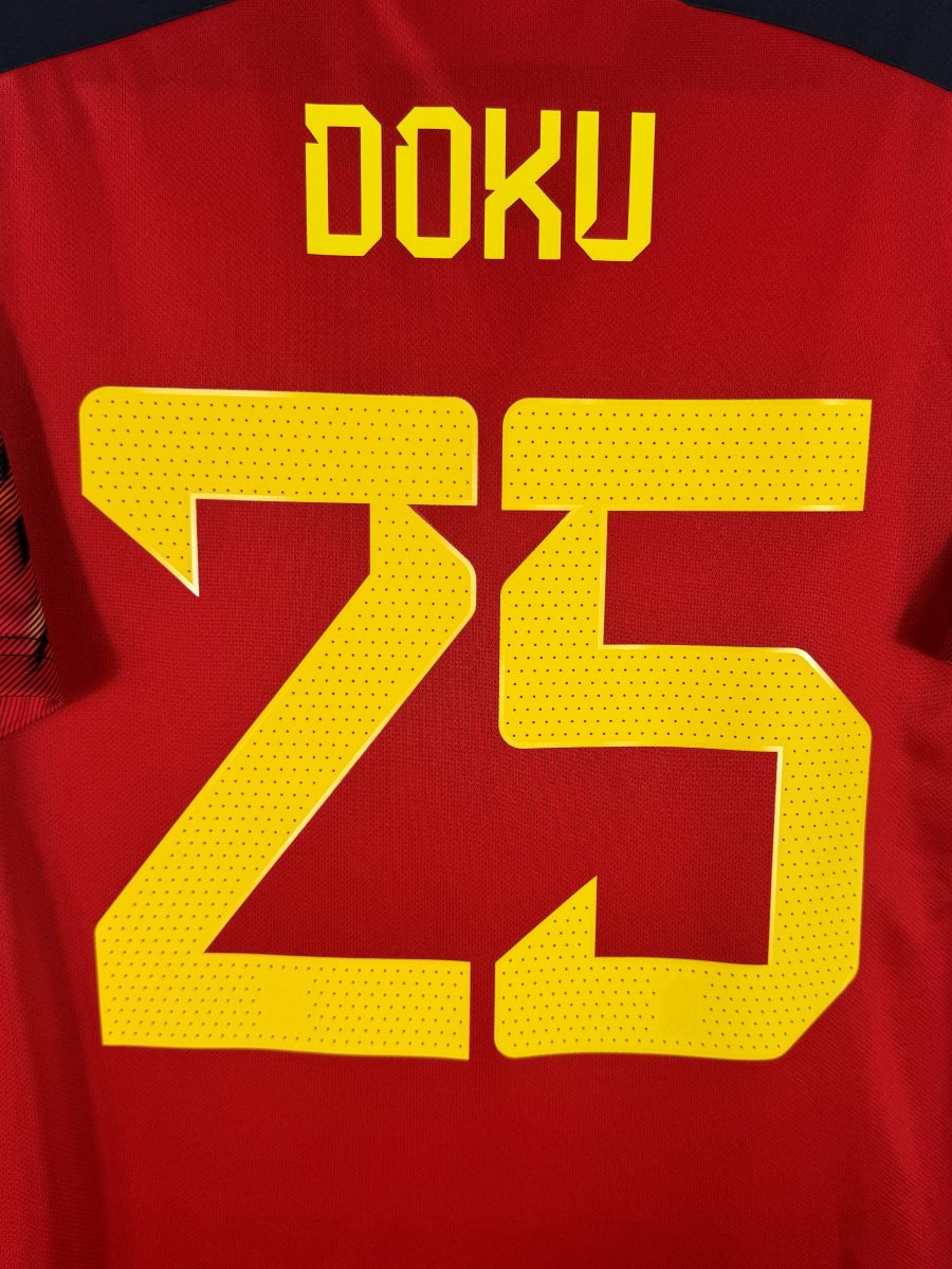 Gros plan du flocage perforé jaune DOKU N°25 du maillot Belgique 2022