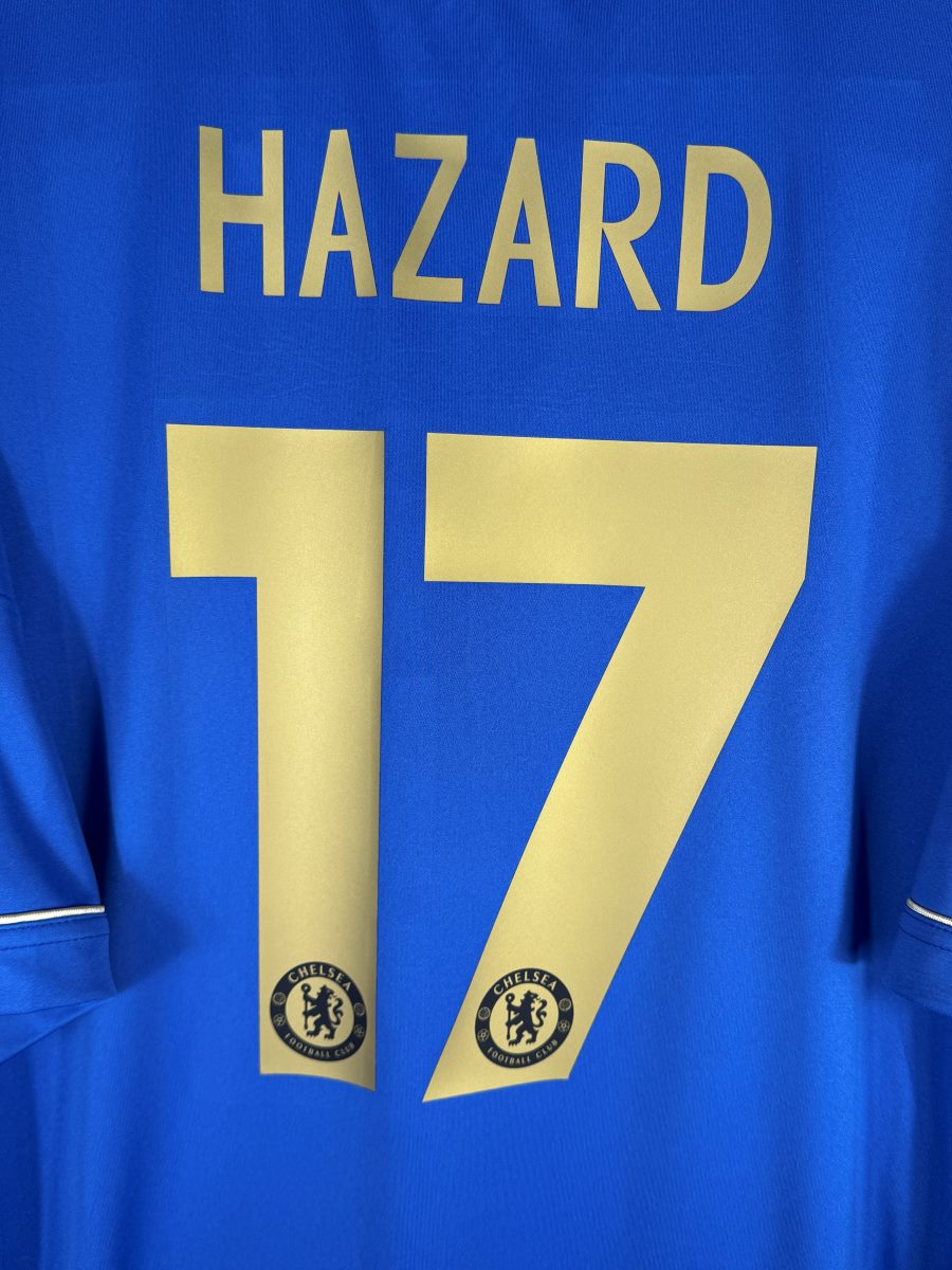 Gros plan du flocage dore Hazard numero 17 avec ecussons Chelsea