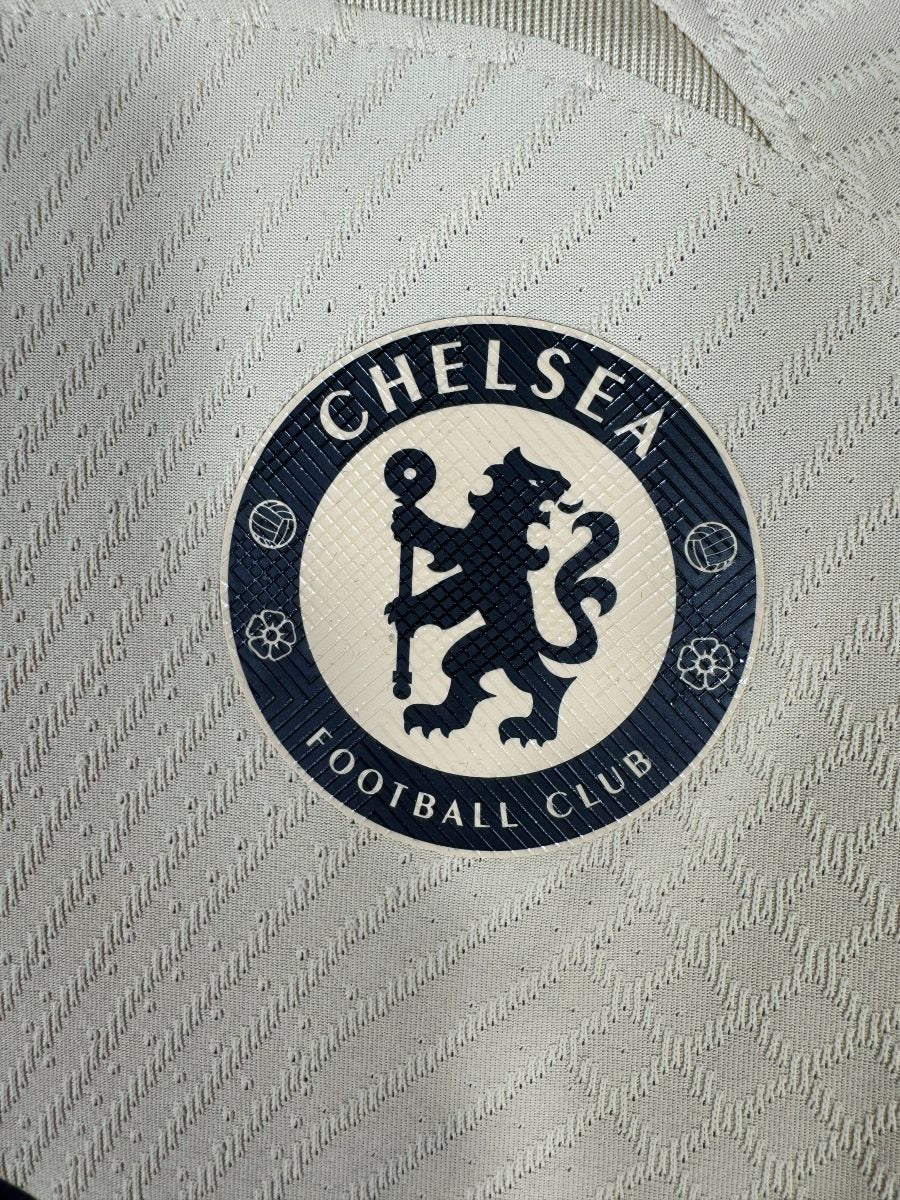 Gros plan de l'écusson Chelsea au lion sur le tissu jacquard du third 2022-2023 version joueur