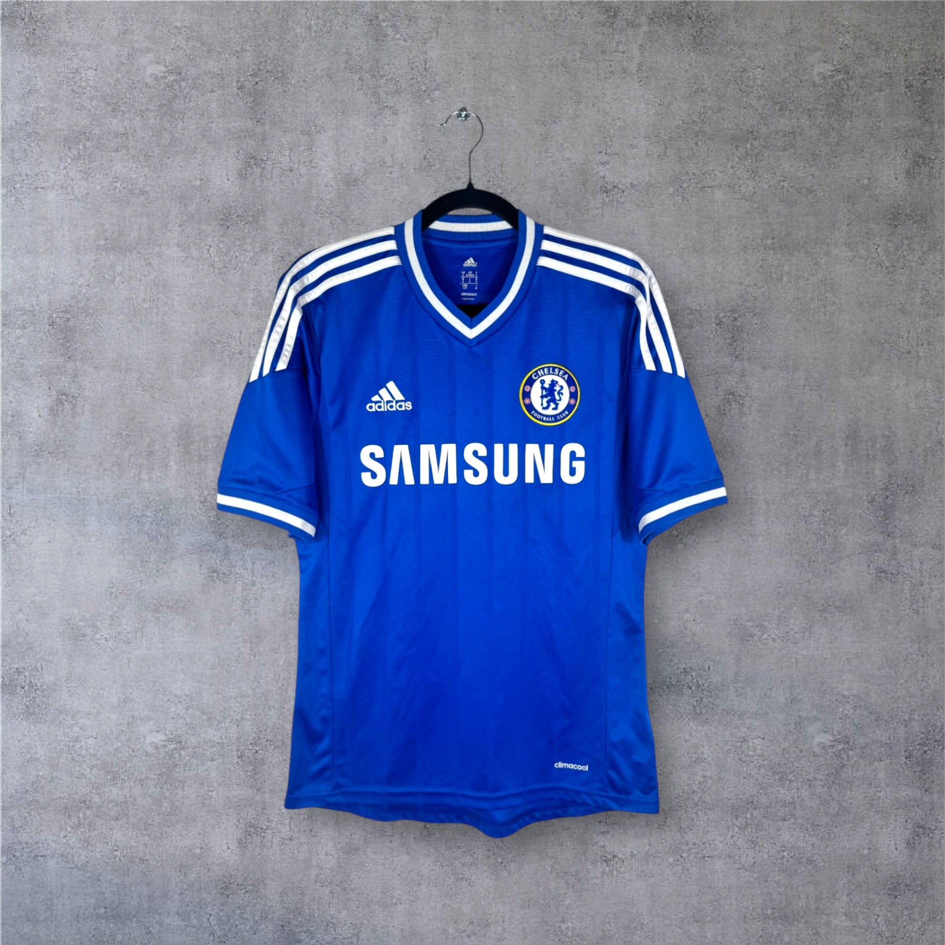 Vue de face du maillot bleu Chelsea 2013/14 avec col blanc et bandes Adidas.
