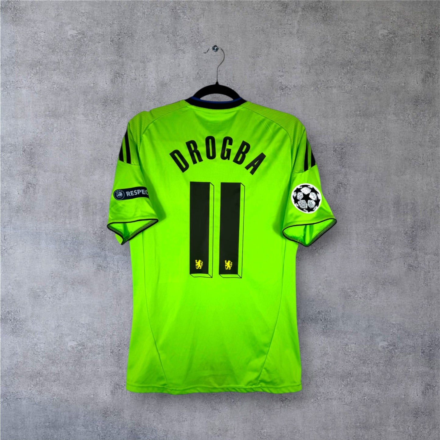 Flocage officiel Drogba 11 avec patchs Ligue des Champions sur maillot Chelsea vert fluo.