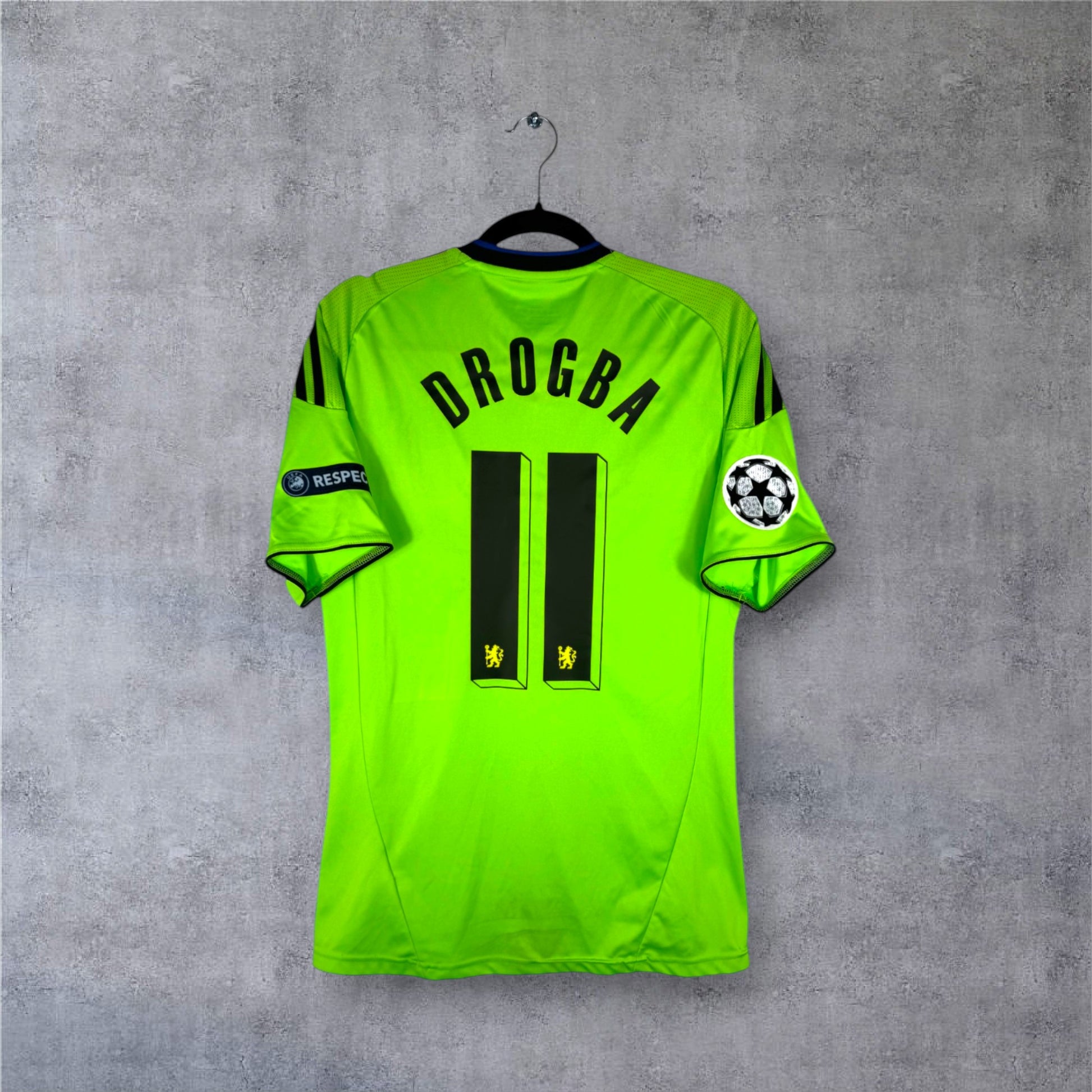 Flocage officiel Drogba 11 avec patchs Ligue des Champions sur maillot Chelsea vert fluo.