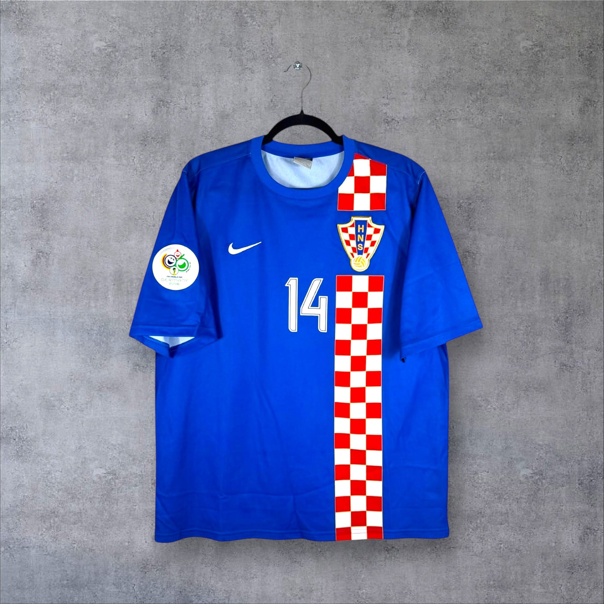 Vue de face du maillot Croatie Extérieur Coupe du Monde 2006 bleu avec bande verticale à damier et numéro 14.
