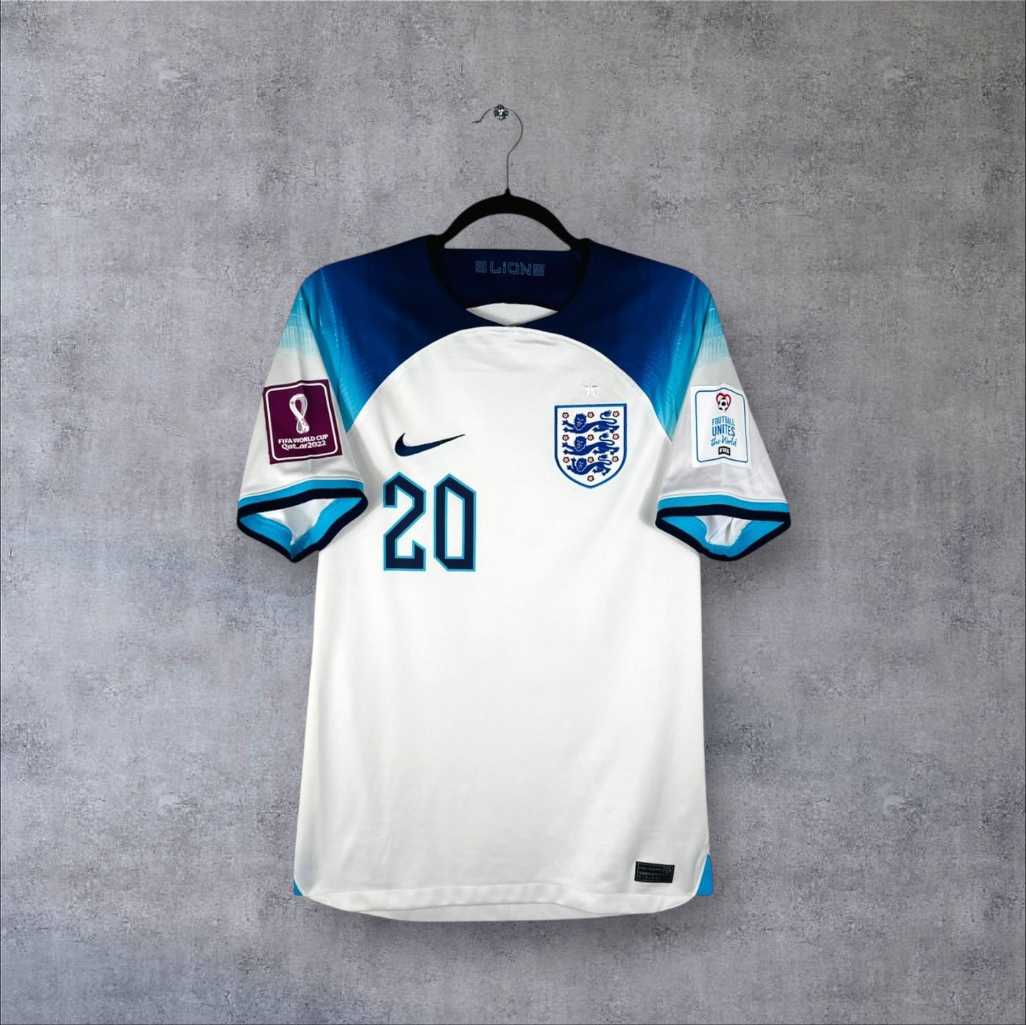 Vue de face du maillot Angleterre Domicile 2022 blanc avec dégradé bleu sur les manches et numéro 20.