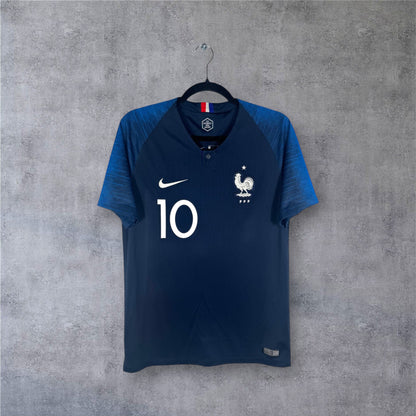 Vue de face du maillot bleu France 2018 avec col boutonné et numéro 10 poitrine.